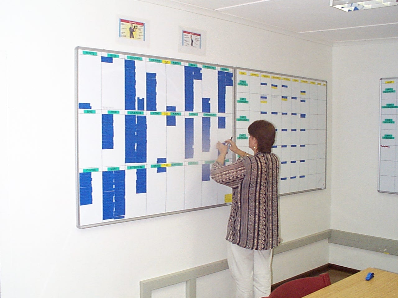 Team member updating the Koingnaas planning board, writing onto a job card.